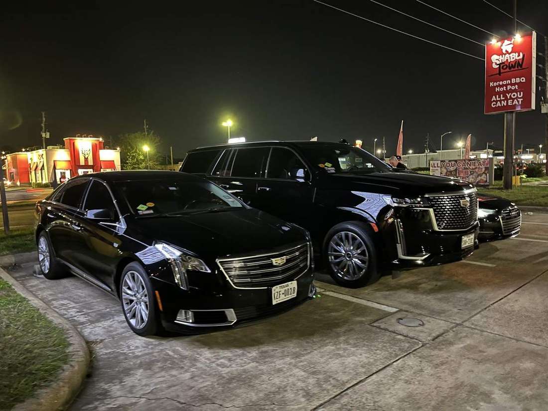 Cadillac XTS sedan Cadillac Escalade night — Houston Limo Chauffeur
