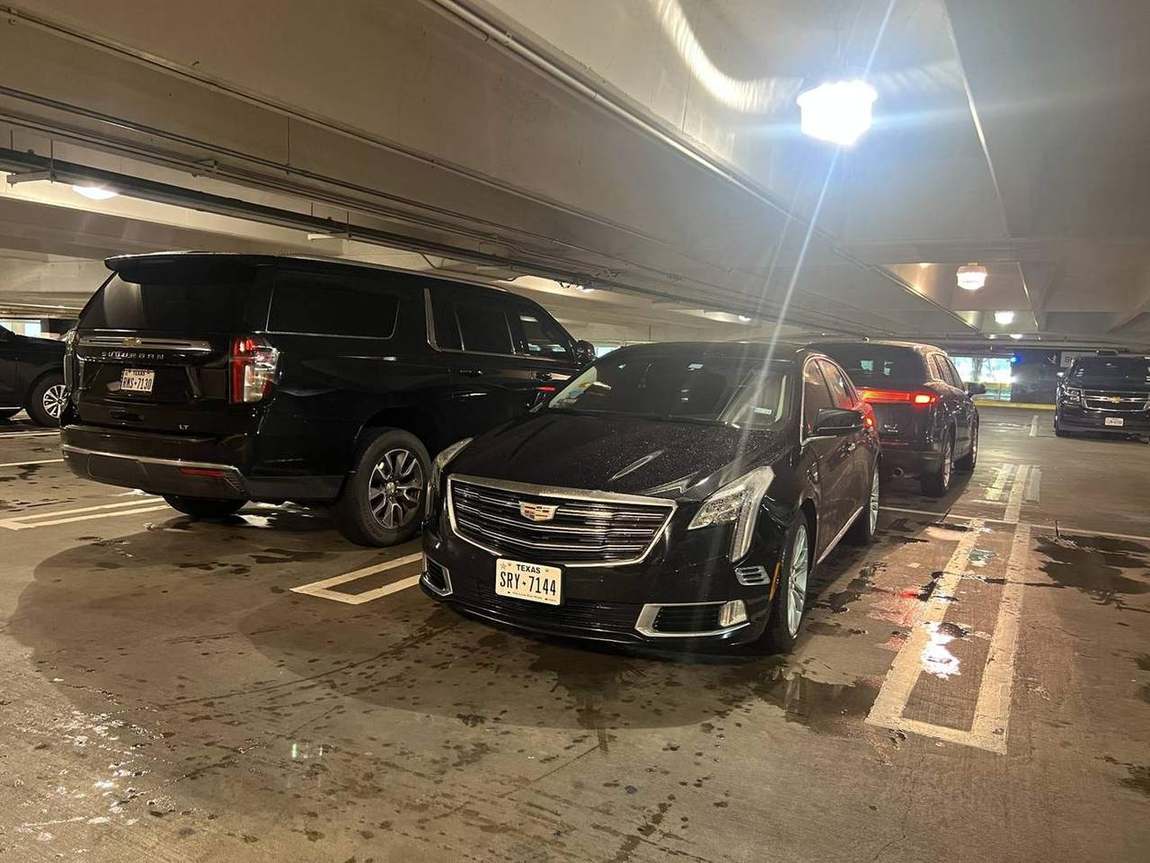 Cadillac XTS sedan Chevy Suburban garage — Houston Limo Chauffeur